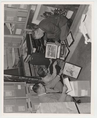 Examining framed photographs in the Alben Barkley collection are, from left, Professor Bennett Wall, Dr. Jacqueline Bull, and Professor Thomas D. Clark