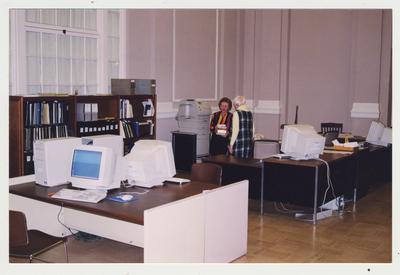 Claire McCann (left) and Terry Warth (right) standing at the reference desk in the Great Hall and S . C. A. Research Room