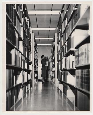 A man and woman look at books in the Medical Center Library at the Medical Center dedication