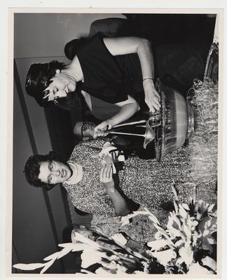 A woman pours punch for a man at the reception after the Medical Center dedication