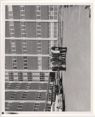 Men stand out front of the newly finished College of Dentistry building