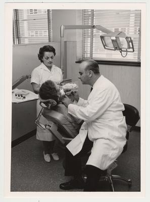 Dr. Michael T. Romano, Chairman of the Department of Operative Dentistry and his assistant use the 