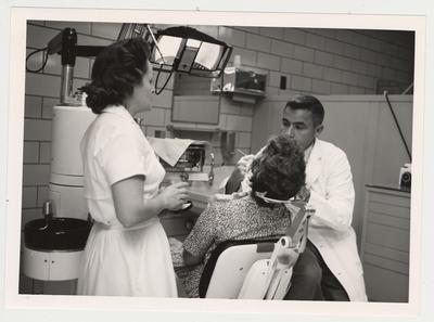 Dr. Harry Bohannon, Chairman of the Department of Perodontics and Endodontics, and his assistant treat a patient in the Dental Emergency Room, located on the first floor of the Dental Sciences Wing