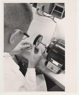 A dentistry student using a machine