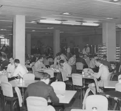 Students eating and socializing the Student Union cafeteria; man on extreme left looking at camera is Bill Brooks