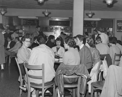 Students eating and socializing the Student Union Grill, in the basement of the Student Union; photo appears in the 1957-58 K-Book, page 58; Public Relations photo
