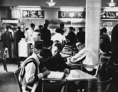 K-Lair Grill, former cafeteria in Student Union basement; front table, left to right, unidentified, Bob Deitz