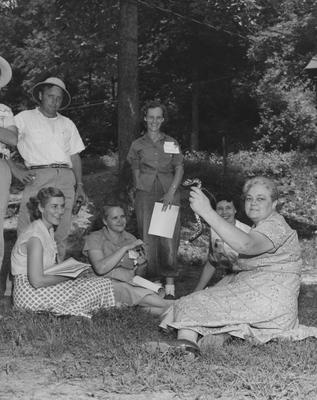 Camp Robinson; unidentified woman holds a snake, with group of other unidentified campers