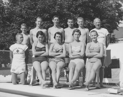 Children of Carnahan House members posing near swimming pool; first two swimmers seated are the Ades twins; Frank J. Ogden is on the back, far right