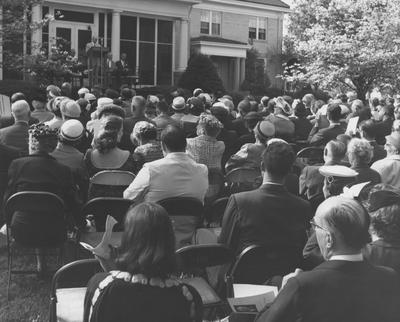 Group of people outside listening to a speaker at the dedication ceremony of the Carnahan House