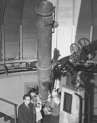 Ronald Nolan Gordon, unidentified woman, and Dr. J. C. Eavens (head of the Math Department) are in an observatory. The observatory was demolished 1964-1965. On January 13, 1958, this photo was received by Pubic Relations