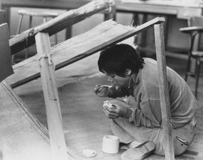An unidentified student is eating in Pence Hall while working on a project. This photo appears first on page 193 in the 1969 