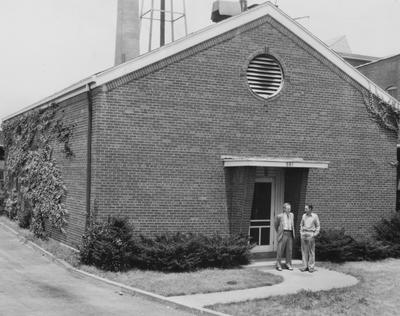 Two unidentified men are standing outside of the Coal Research Laboratory. Photographer was Mark Huges