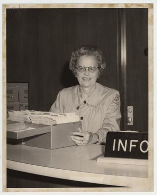 Daisy Croft sits at an information desk