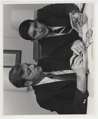 Two men look at brochures