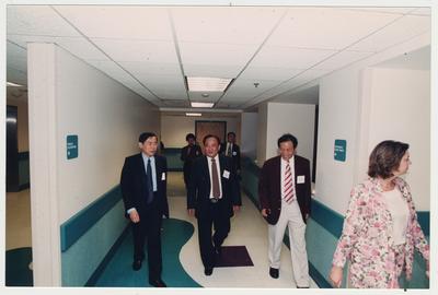 Visitors from Shandong University Medical School in Shandong Ji ' Den, China taking a tour of the Medical Center with an unidentified woman