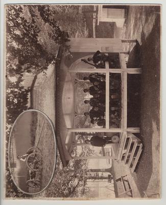 Scene of encampment of State College cadets near Ashland, Kentucky.  10 men with instruments posing on a gazebo.  Inset picture of a man on a wagon