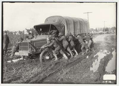 University of Kentucky military training during World War I.  Cadets pushing a truck through the mud