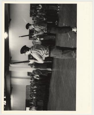 A drill team competition, two cadets performing with rifles