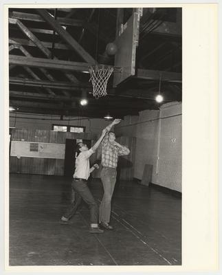 Two unidentified men playing basketball in Buell Armory