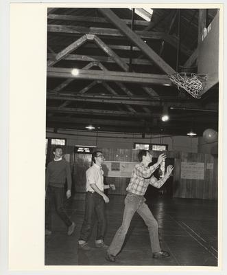 Three unidentified men playing basketball in Buell Armory
