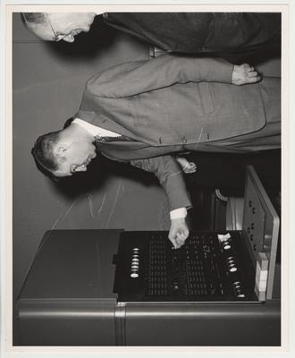 President Frank Dickey standing (on the right) with two unidentified men (on the left) at the computer