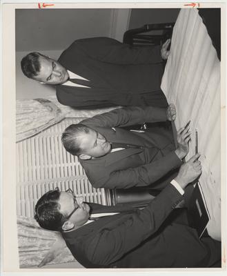 Vice President Stanley Wall (left), Governor Bert Combs (center), and President Frank Dickey are reviewing plans for the Agricultural Research Center.  This photo is in the Visual Print File, image 157