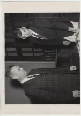 President Frank Dickey (left) examining documents with an unidentified man