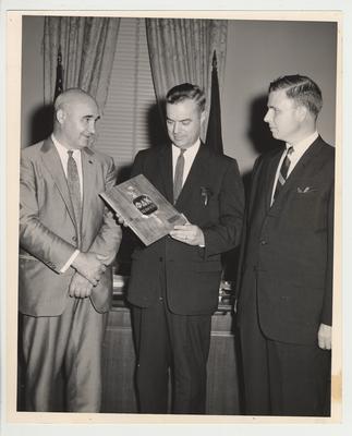 President Frank Dickey (center) holding a plaque for the Phi Delta Kappa Service Award.  The other two men are unidentified