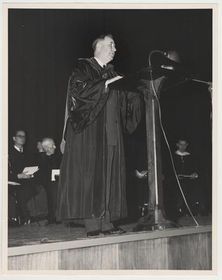 President Donovan speaking at the dedication of the Fine Arts Building on the Guignol Theater stage.  Men in background from the left: unidentified, Professor Ezra L. Gillis, unidentified, Professor W. N. Briggs