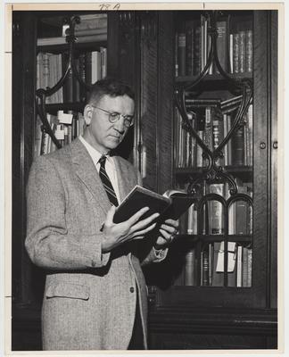 Dean of the Graduate School, Albert Kirwan reading a book