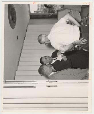 President John W. Oswald (second man from the left) is conversing with two unidentified men in the Student Center