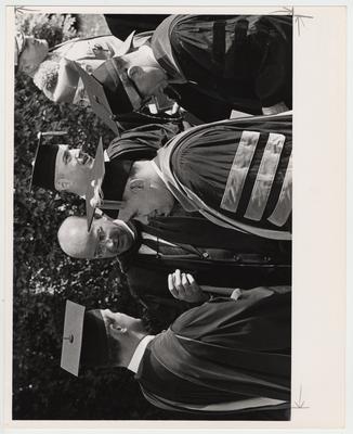 President John Oswald (second form left), former president Frank Dickey (third from front, behind a man wearing glasses) and other unidentified people standing outside for Oswald's inaugural ceremonies