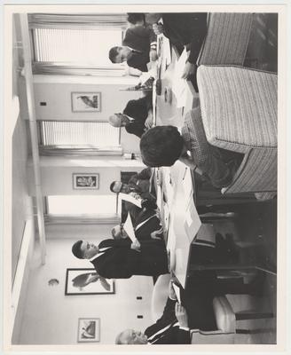 President John Oswald (sixth from the left) and six other unidentified members of the Executive Committee of Trustees sit around a table at a meeting in Henderson, Kentucky