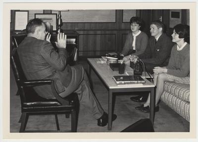 President John Oswald talking with three students in his office
