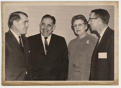 President Oswald standing with two unidentified men and one unidentified woman