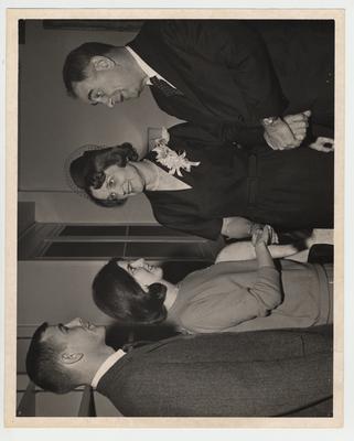 President John Oswald (standing on the far right) and his wife Rosanel (second from the right) talking to two unidentified people