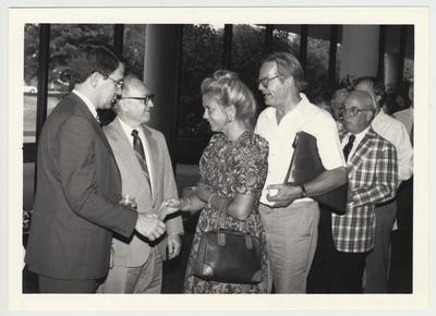 President Roselle (far left) standing and greeting unidentified people at the 1987 Faculty Reception
