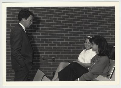 President Roselle (left) standing and speaking to two unidentified female students at the University Senate Meeting