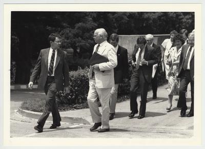 President Roselle (front, left) walking with a group of unidentified people at the 1987 Legislative Tour