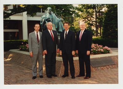 President Roselle (second from the right) and three unidentified men standing in from of the James Patterson statue in front of the Administration building and near the Patterson Office tower