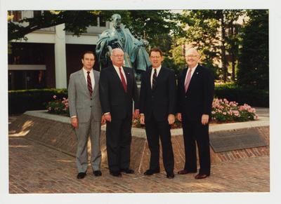 President Roselle (second from the right) and three unidentified men standing in from of the James Patterson statue in front of the Administration building and near the Patterson Office tower