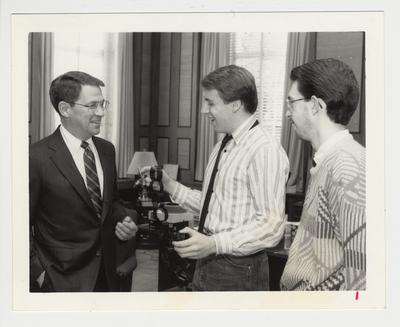 President Roselle (left) standing with two unidentified men.  The man in the center is holding the 
