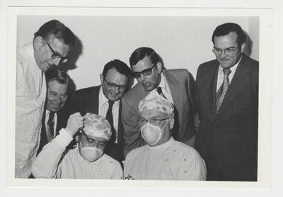 President Singletary (far left), two doctors (Dr., Peter Bosomworth, Chancellor of the Medical Center is in the front of the right), and four unidentified men performing a proctoscopy