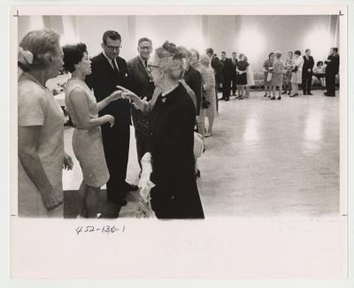 A receiving line for Doctor Otis Singletary's introduction to the University Community as the new University President in 1969.  On the receiving line (left) are (from left to right) Elizabeth Kirwan, the spouse of retiring president Albert Kirwan; Gloria Singletary, spouse of new president Otis Singletary; Doctor Otis Singletary; and retiring president Albert Kirwan.  This photo is in the 1969 Kentuckian on page 136