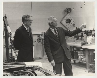 An unidentified man is showing president Singletary around a shop