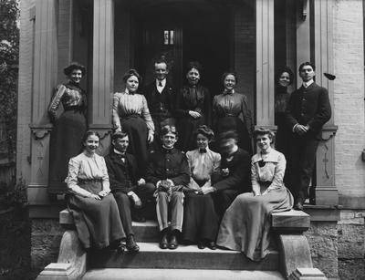 A group of unidentified people on the front steps of the Carr Boarding House. Carr is the name of the owner of the house