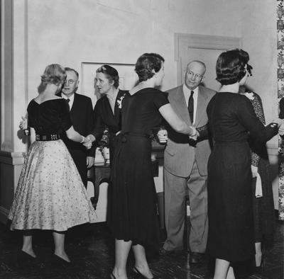 President Herman Donovan (far from left) is conversing with an unidentified woman and unidentified people are conversing at the dedication of Keeneland Hall on October 17, 1955. Photographer: Herald-Leader