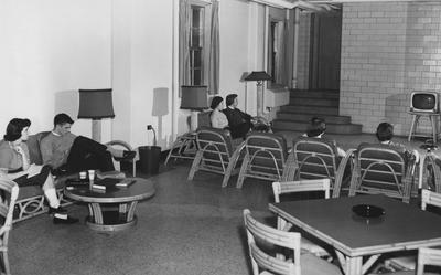 Five unidentified women and one unidentified man are all watching television in Keeneland Hall. Keeneland Hall was named after the Keeneland Foundation which donated $200,000 and on October 17, 1955, it was dedicated to the foundation. Received March 16, 1957 from Public Relations