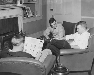 Three unidentified men are reading in Kinkead Hall, a men's dormitory. Kinkead Hall was built in 1929 and was named after William B. Kinkead